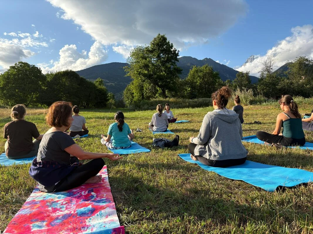 Yoga on the meadow facing Mount Ushba